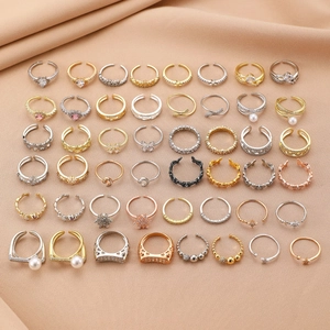 Collection of fashion open rings with pearls and zircons on beige satin fabric