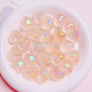 Luminous heart-shaped Aurora beads in a white ceramic dish for DIY craft projects