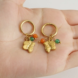 Détail de créole plaquée or 18k avec pendentif abeille dorée et perles colorées