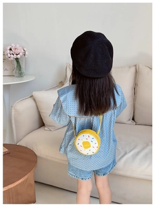 Detail of yellow donut-shaped crossbody bag for girls with Hello print and colorful patterns