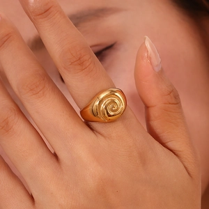 Macro detail of 18K gold plated stainless steel ring with elegant spiral texture