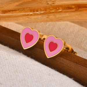 Detailed view of double heart-shaped earrings with red and pink enamel in gold setting