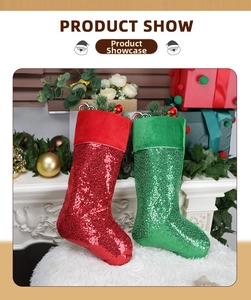 Detail of red and green sequined Christmas stockings filled with festive berries and pine