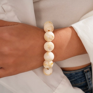 Detailed shot of large acrylic marble textured beads bracelet on a female wrist