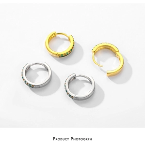 Detail of S925 sterling silver hoop earrings with green and white gems in gold and silver