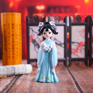 Detail of girl in blue hanfu holding white cat figurine with ancient Chinese screen