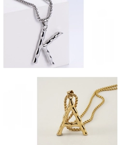 Detail of 18K gold and silver hip hop alphabet pendants with irregular liquid metal texture
