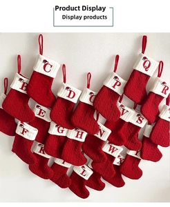 Set of classic red knitted Christmas stockings with embroidered letters on white cuffs