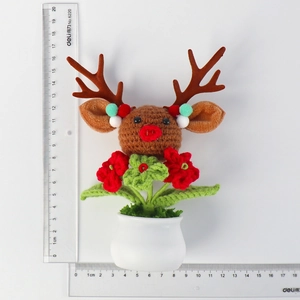 Handmade crochet reindeer potted plant with festive red and green yarn flowers