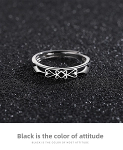 Detail of adjustable metal ring featuring black enamel and white geometric heart pattern