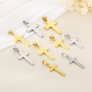 Close-up of assorted gold and silver polished cross pendants with textured details