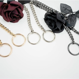 Detail view of gold, silver, and gunmetal stainless steel Cuban link chains with ring charms
