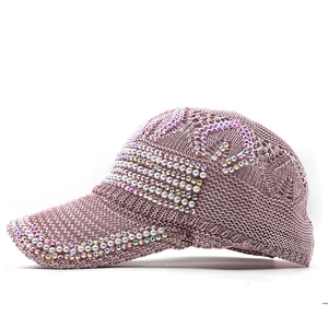 Nahaufnahme einer rosa Strickmütze mit Strasssteinen und Perlenstickerei für Damen