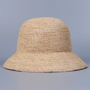 Gros plan sur le chapeau cloche en raphia fait main avec des détails de tissage serré