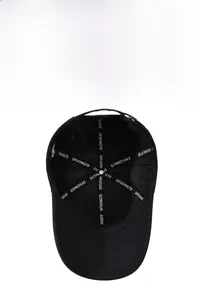 Structure interne d'une casquette noire avec coutures renforcées et rubans logo