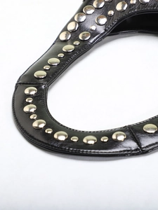 Macro detail of silver rivets on black pebbled leather strap for punk style shoulder bag
