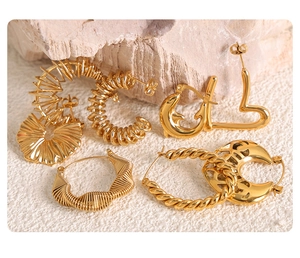 Macro view of assorted 18k gold plated stainless steel earrings on natural stone