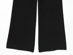 Vue détaillée du pantalon noir large montrant la texture du tissu et la finition de l'ourlet