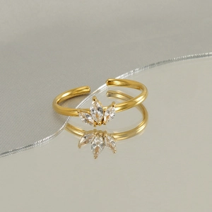 Detail of adjustable gold maple leaf ring with marquise-cut cubic zirconia on a mirror