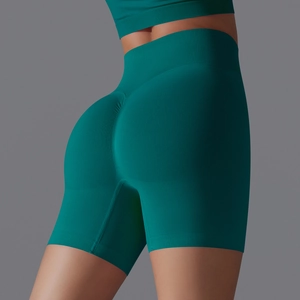 Close-up of high-waisted seamless dark green yoga shorts with scrunch butt lifting effect