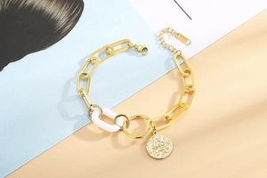Détail d'un bracelet chaîne en acier doré 18K avec anneau blanc et pendentif en relief
