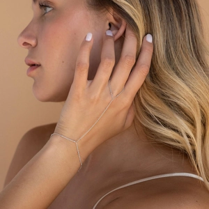 Minimalist silver hand chain jewelry featuring a sleek finger ring and thin wrist bracelet