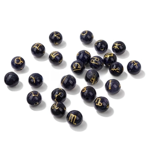 Macro detail of 10mm blue goldstone beads with golden zodiac symbols for DIY jewelry