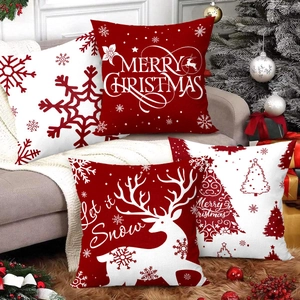 Set of 4 Christmas pillow covers with reindeer and snowflake prints on a cozy sofa