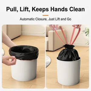 Thick black drawstring trash bags with red handles showing automatic closure design