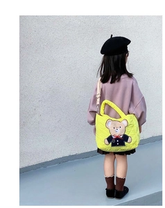 Detail of yellow quilted crossbody bag for kids featuring a cute cartoon bear embroidery