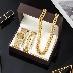 Close-up of luxury gold iced-out watch, cuban necklace and bracelet set in a gift box
