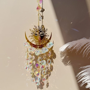 Detail of sun and moon suncatcher reflecting colorful rainbow spots on a wall