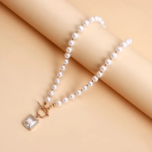 Detail of pearl necklace with gold OT toggle clasp and rectangular zircon pendant