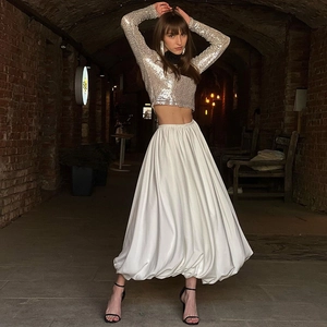 Modieuze damesoutfit met zilveren lovertjes crop top en witte uitlopende maxi rok set