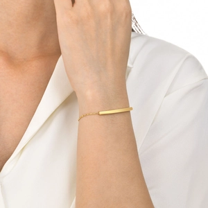 Close-up of minimalist gold rectangular bar bracelet on female model wrist