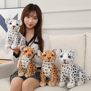 Detailed view of snow leopard and leopard plush toys held by a model for size reference