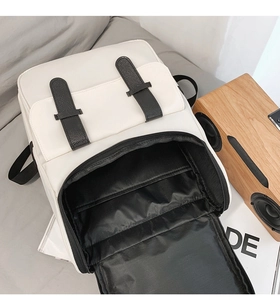 Interior view of beige backpack showing black lining and laptop compartment storage