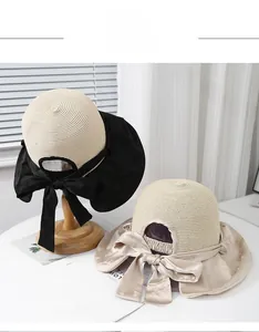 Detail of wide straw hat brim with elegant satin ribbon bow and adjustable strap