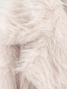 Macro detail of soft cream faux fur texture and fluffy fibers on this cozy winter coat