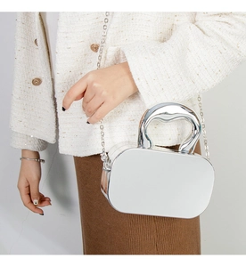 Close-up of metallic silver mirror handbag with chain strap and unique top handle