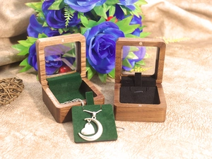 Detail of walnut wood jewelry box with green velvet lining and heart pendant necklace