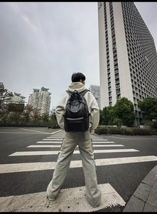 Vista street style di un grande zaino nero in pelle PU indossato da un modello in città