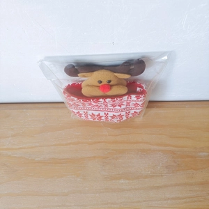 Close-up of a Christmas reindeer plush bag with red snowflake knit container in packaging