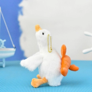 Close-up of a cute white plush goose keychain with a golden chain on blue background