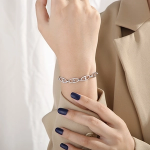 Close-up of minimalist silver stainless steel anchor link bracelet on female model wrist