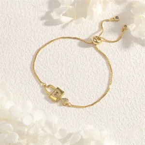 Close-up of golden heart lock bracelet with white zircons and adjustable sliding clasp