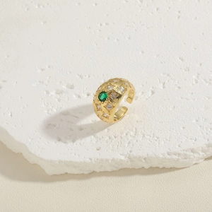 Close-up of gold arched ring with green oval gemstone and clear zircon accents
