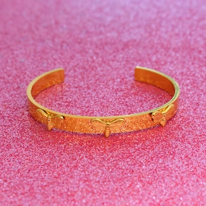 Gros plan détaillé du bracelet jonc doré orné de trois motifs d'abeilles 3D sur paillettes