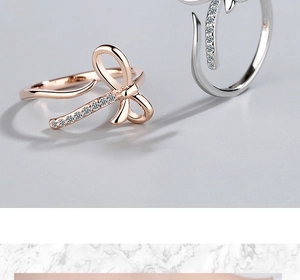 Macro shot of rose gold and silver bow rings with sparkling cubic zirconia pavé