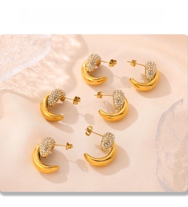 Macro view of gold PVD plated crescent earrings featuring dense pavé cubic zirconia